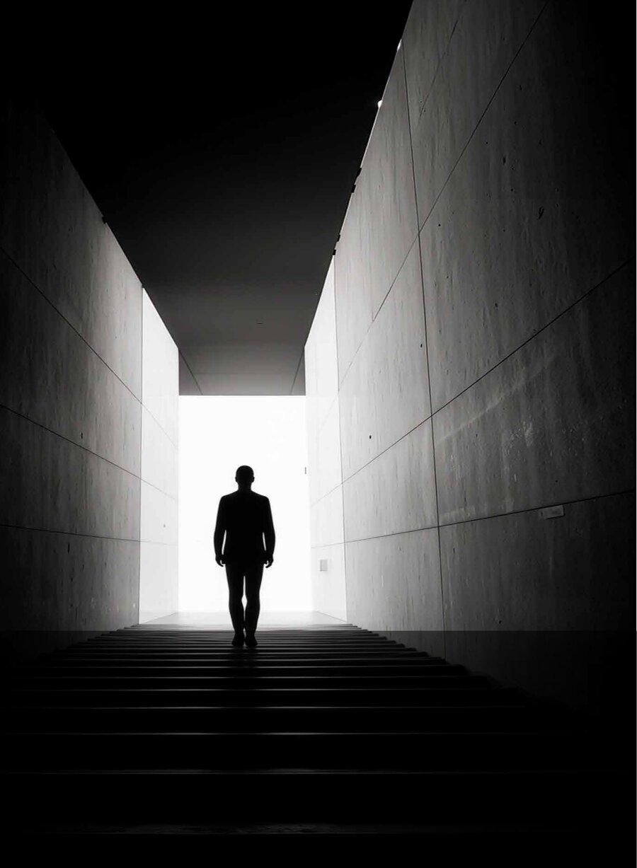 A figure walking up a corridor towards the light
